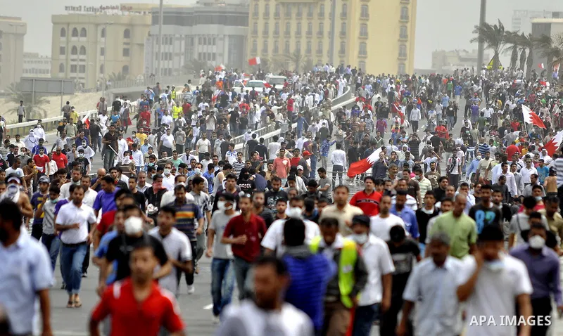 Anti-government protesters react to tear gas fired by riot police Sunday, March 13, 2011, along a main highway in Manama, Bahrain. Photo by Ammar A.rasool