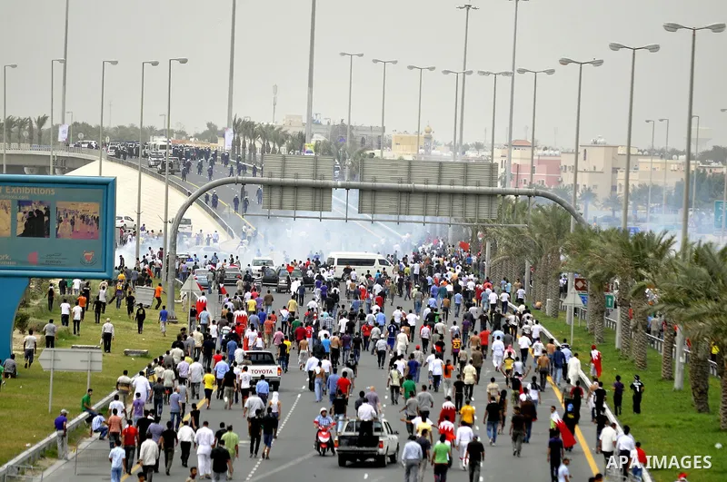 Anti-government protesters react to tear gas fired by riot police Sunday, March 13, 2011, along a main highway in Manama, Bahrain. Photo by Ammar A.rasool