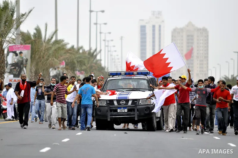 Anti-government protesters react to tear gas fired by riot police Sunday, March 13, 2011, along a main highway in Manama, Bahrain. Photo by Ammar A.rasool