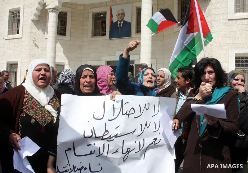 Palestinian women protestors hold national flags and banners calling for the national reconciliation in front of the Governorate of Hebron in the West Bank city of Hebron,on March 13, 2011. Photo by Najeh Hashlamoun