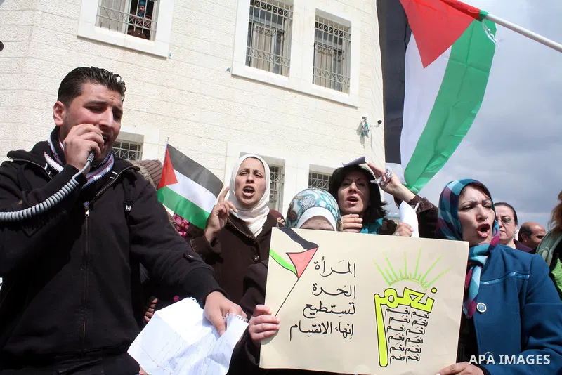 Palestinian women protestors hold national flags and banners calling for the national reconciliation in front of the Governorate of Hebron in the West Bank city of Hebron,on March 13, 2011. Photo by Najeh Hashlamoun