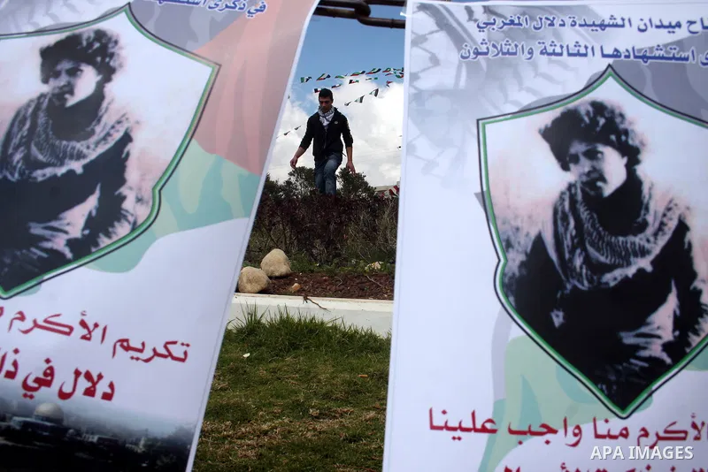 Palestinians hang banners in the West Bank city of Ramallah with pictures of Fatah member Dalal Mughrabi, who led an attack on an Israeli bus near Tel Aviv, killing 36 people in 1978, on the 32nd anniversary of the attac...