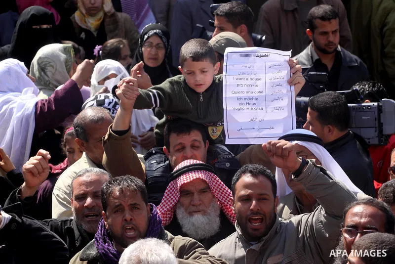 Palestinian lost their homes during the Israeli war in 2008-2009 attend a gathering calling for ending the siege in front of the United Nations Relief and Works Agency (UNRWA) headquarters in Gaza City March 13,2011. Pho...