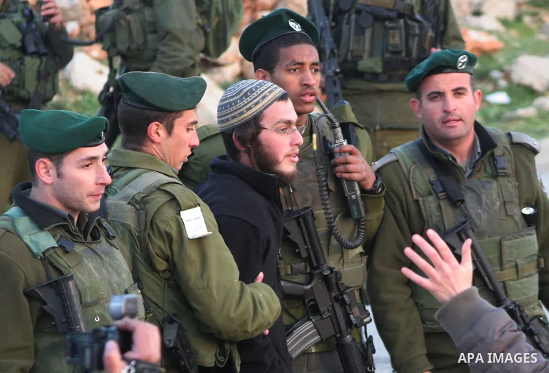 Israeli border policemen detain an Israeli settler after a group from the Kiryat Arbaa settlement attacked Palestinian cars and homes and blocked a main road in the West Bank city of Hebron on March 13, 2011. Israeli pol...