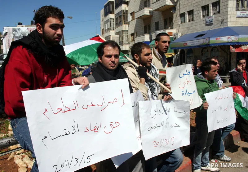 Palestinians participate in a march calling for a reconciliation between the rival Palestinian leading factions Hamas in Gaza and Fatah in the West Bank, in Ramallah, Monday, March 14, 2011. Photo by Issam Rimawi