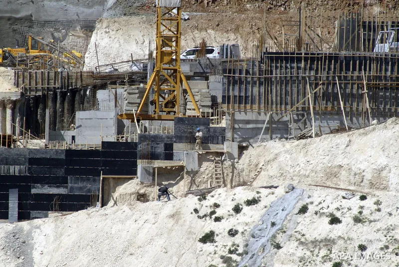 Palestinian labourers work in an Israeli settlement of Harmon Hanatziv in East jerusalem, Monday, March 14, 2011. The U.S. Embassy said Monday it was "deeply concerned" by Israel's plans to build hundreds of new homes in...
