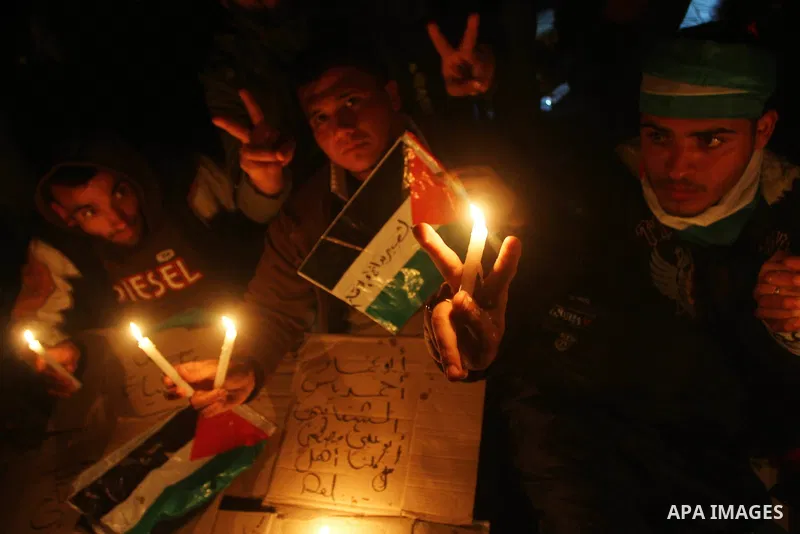 Palestinian demonstrators hold candles and placards as they prepare to spend the night on the street during a rally in Gaza City, calling for an end to Palestinian divisions March 14, 2011. Some 500 Palestinians, answeri...