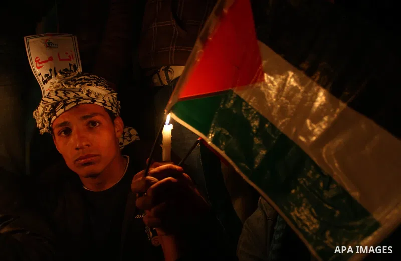 Palestinian demonstrators hold candles and placards as they prepare to spend the night on the street during a rally in Gaza City, calling for an end to Palestinian divisions March 14, 2011. Some 500 Palestinians, answeri...