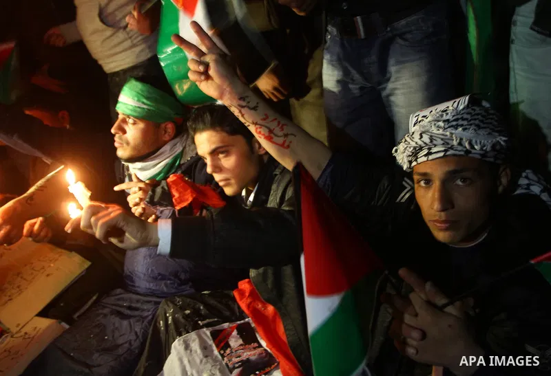 Palestinian demonstrators hold candles and placards as they prepare to spend the night on the street during a rally in Gaza City, calling for an end to Palestinian divisions March 14, 2011. Some 500 Palestinians, answeri...