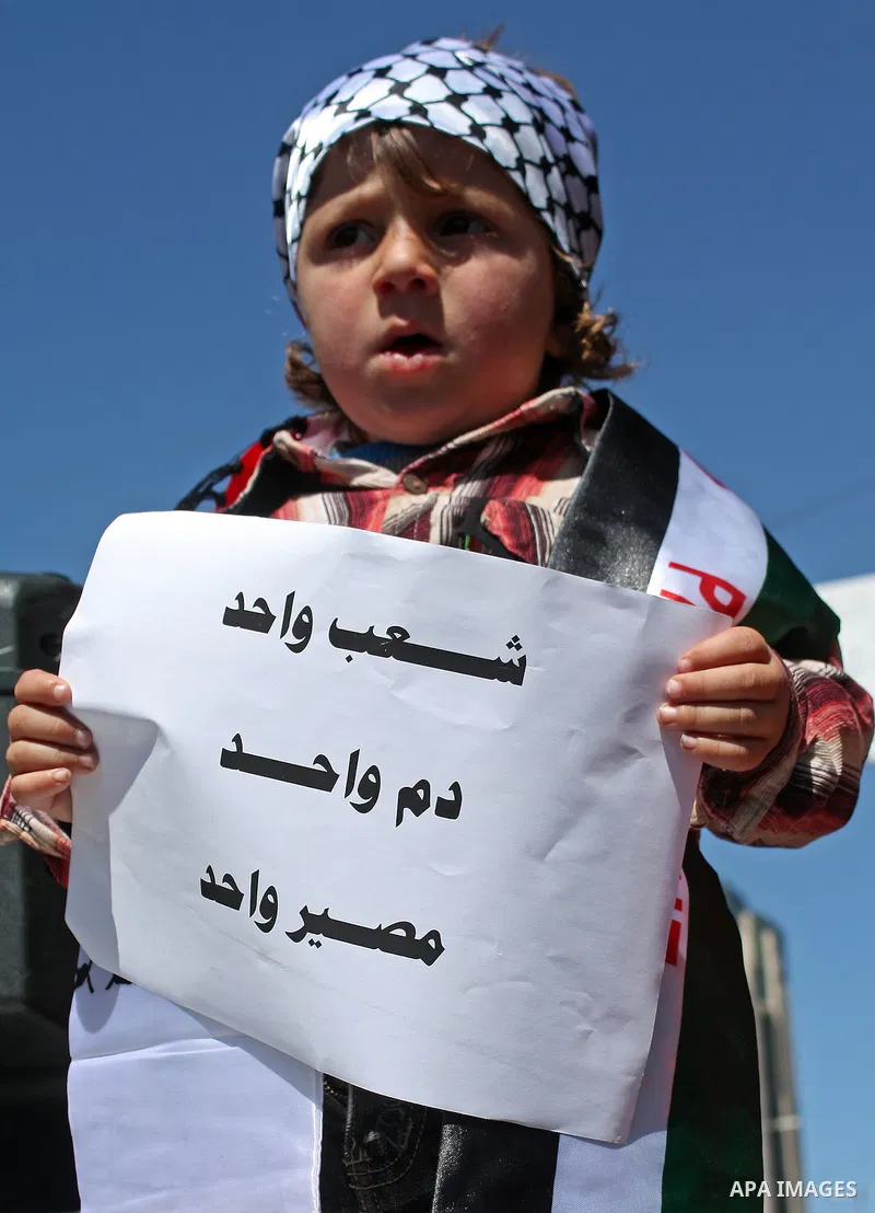 A Palestinian child holds a slogans during a protest calling for Palestinian political unity between Gaza's Hamas rulers and the Fatah-dominated Palestinian Authority which rules from Ramallah, on March 15, 2011 in Hebro...