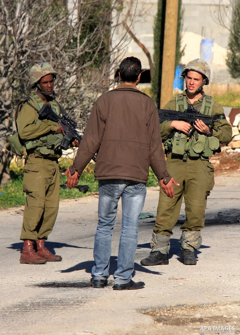 Israeli soldiers stop a Palestinian youth , during an operation by the Israeli military in the village of Awarta near the Jewish settlement of Itamar,Tuesday, March 15, 2011. Photo by Wagdi Eshtayah