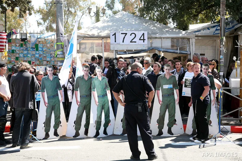 Israeli activists hold up banners in front of the Israeli Prime Minister's house during a five-minute protest calling for the release of captured Israeli soldier Sgt. Gilad Schalit in Jerusalem Tuesday, March 15, 2011. T...