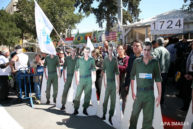 Israeli activists hold up banners in front of the Israeli Prime Minister's house during a five-minute protest calling for the release of captured Israeli soldier Sgt. Gilad Schalit in Jerusalem Tuesday, March 15, 2011. T...