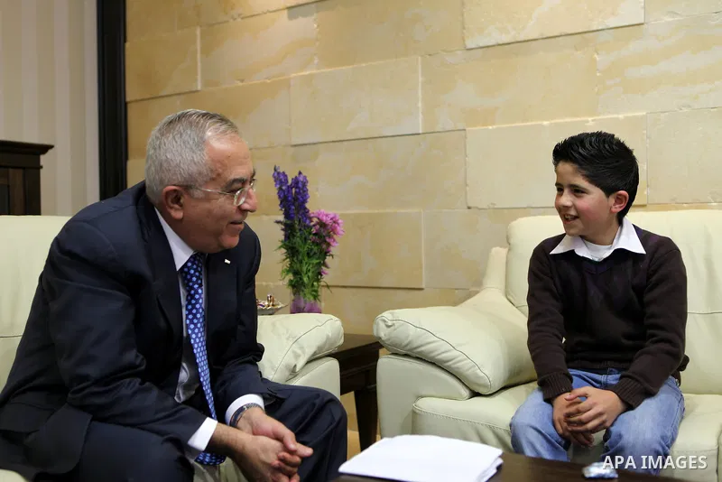 Palestinian Prime Minister Salam Fayyad meets the child Issam Bashiti in the West Bank city of Ramallah March 15, 2011. Photo by Mustafa Abu Dayeh