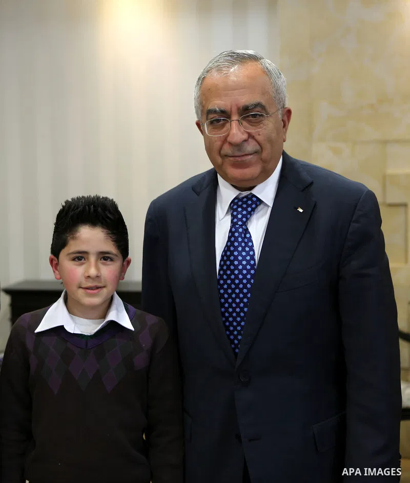 Palestinian Prime Minister Salam Fayyad meets the child Issam Bashiti in the West Bank city of Ramallah March 15, 2011. Photo by Mustafa Abu Dayeh