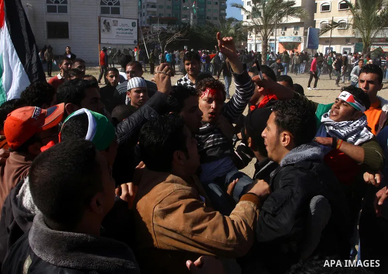 Palestinian demonstrators carry a wounded youth during brief clashes between Hamas supporters and protestors supporting other Palestinian factions, during a rally calling for Palestinian political unity between Gaza's Ha...