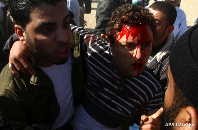 Palestinian demonstrators carry a wounded youth during brief clashes between Hamas supporters and protestors supporting other Palestinian factions, during a rally calling for Palestinian political unity between Gaza's Ha...