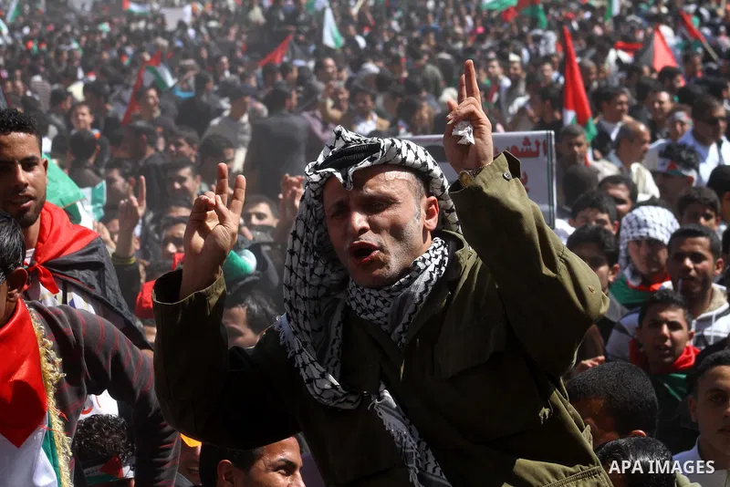A Palestinian dressed like late Palestinian leader Yasser Arafat shouts slogans during a rally calling for Palestinian political unity between Gaza's Hamas rulers and the Fatah-dominated Palestinian Authority which rules...