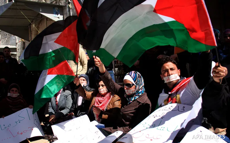 Palestinian demonastrators wave flags and chant slogans in a rally calling for a reconciliation between Fatah in west bank and hamas in Gaza strip., March 16, 2011. Photo by Wagdi Eshtayah