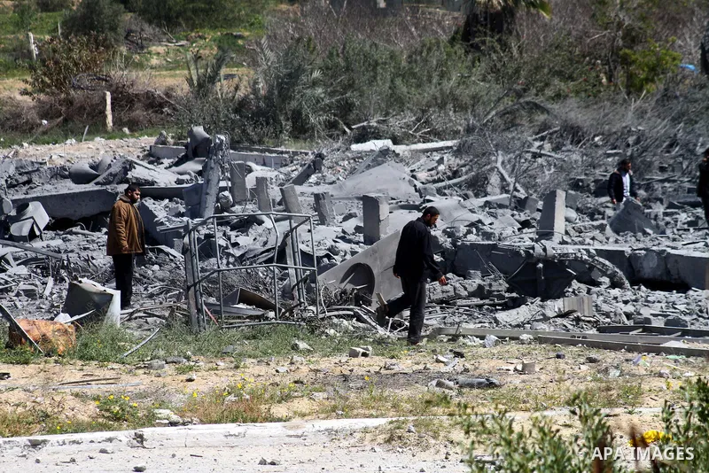 A Palestinian Hamas security officer walks through the rubble after an Israeli air strike on a Hamas training camp on the outskirts of Gaza City, Wednesday, March 16, 2011. Israeli fighter jets pummeled a Hamas facility...