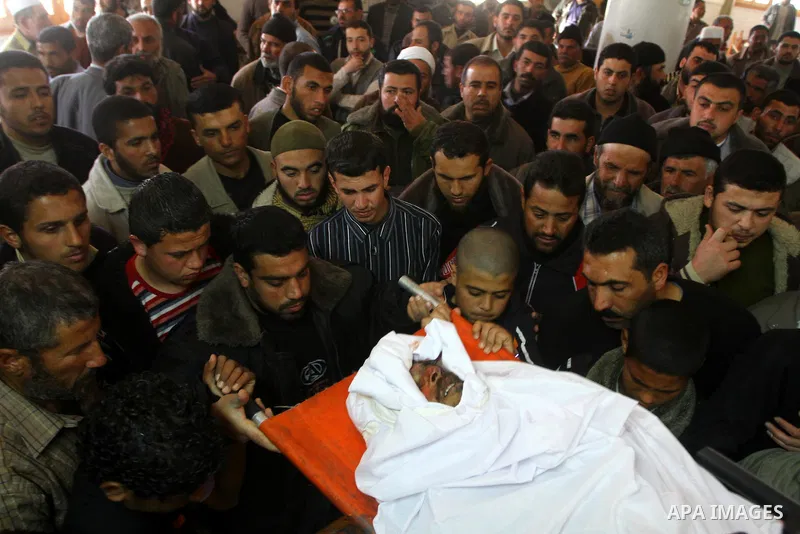 Palestinian Hamas members carry the body of Hamas militant Adnan Eshtewi after he was killed with other another militant in an Israeli warplane strike against a Hamas training camp, during his funeral in al Zaitun area i...
