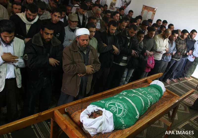 Palestinians pray near the body of Hamas militant Adnan Ishtawe during his funeral in Gaza City March 16, 2011. Israeli warplanes fired two missiles at a security compound in the Hamas-ruled Gaza Strip on Wednesday, kill...