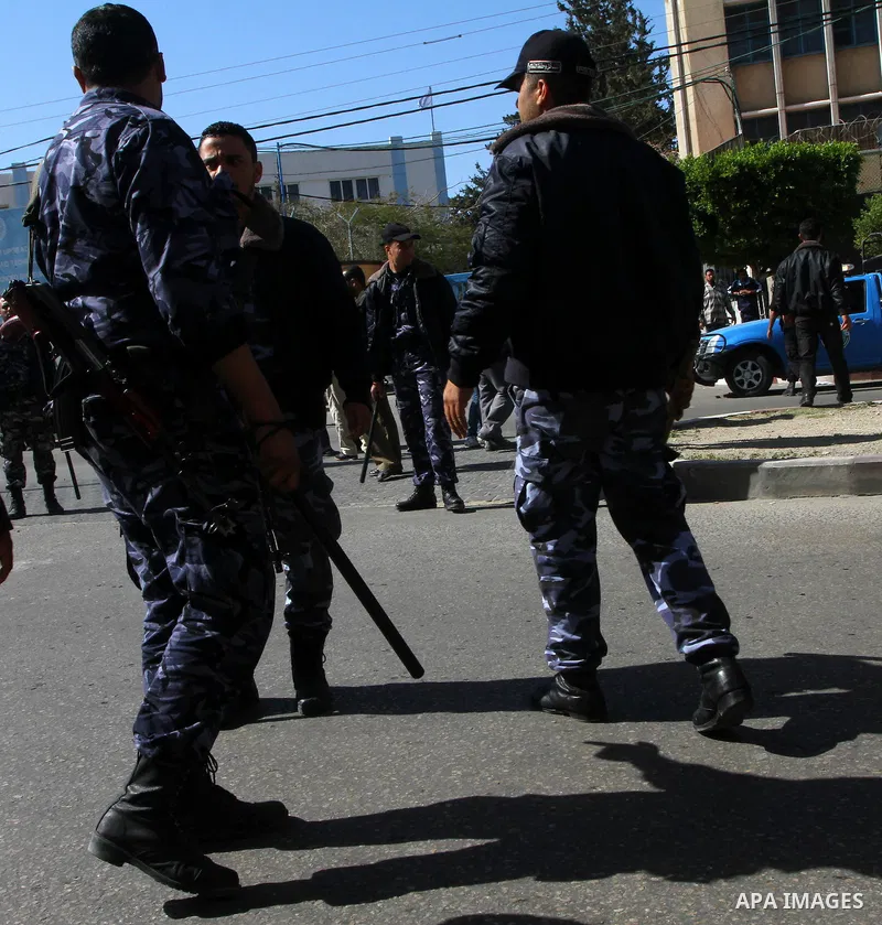 An armed Palestinian Hamas security members tries to disperse Palestinian demonstrators blocking the street opposite the headquarters of the United Nations Relief and Works Agency for Palestine Refugees in the Near East...