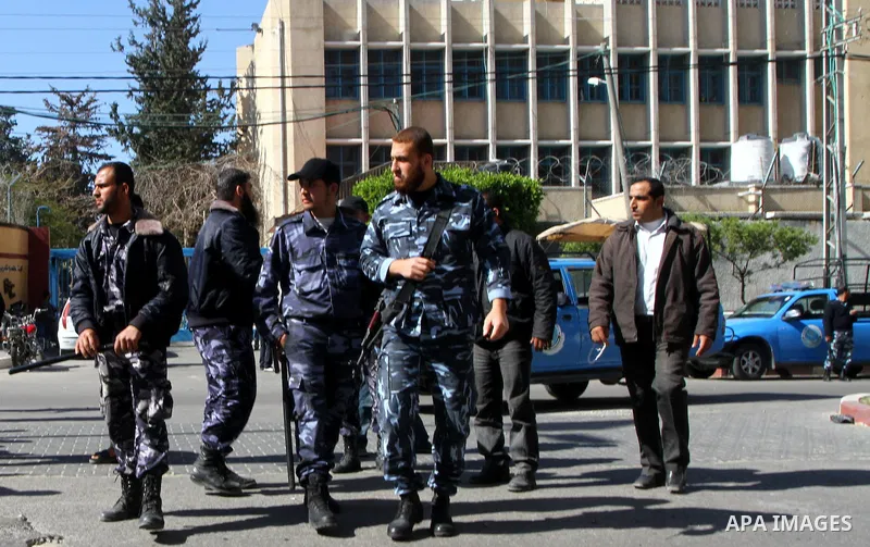 An armed Palestinian Hamas security members tries to disperse Palestinian demonstrators blocking the street opposite the headquarters of the United Nations Relief and Works Agency for Palestine Refugees in the Near East...