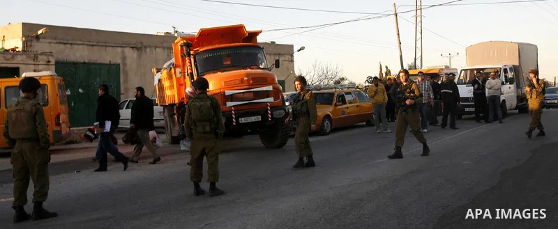 Israeli soldiers stand guard near the Israeli settlement of Qadumim between Qalqilya and Nablus in the West Bank after settlers torched the cars of two Palestinians working inside the settlement on March 17, 201. Photo b...