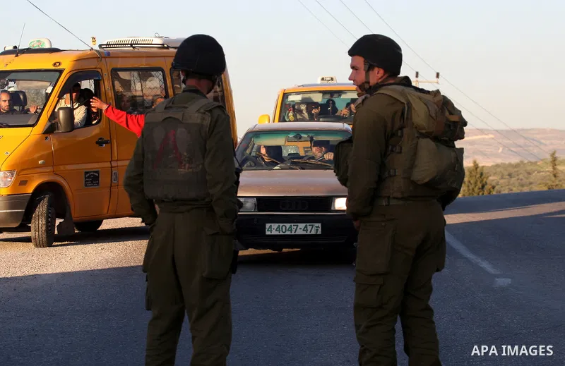 Israeli soldiers stand guard near the Israeli settlement of Qadumim between Qalqilya and Nablus in the West Bank after settlers torched the cars of two Palestinians working inside the settlement on March 17, 201. Photo b...