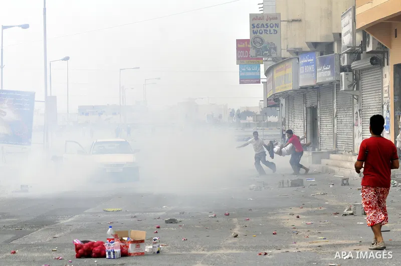 Anti-government protesters run from riot police, Thursday, March 17, 2011, as a tear gas canister explodes nearby in the Shiite Muslim village of Jidhafs, Bahrain, on the outskirts of the capital of Manama. Security forc...