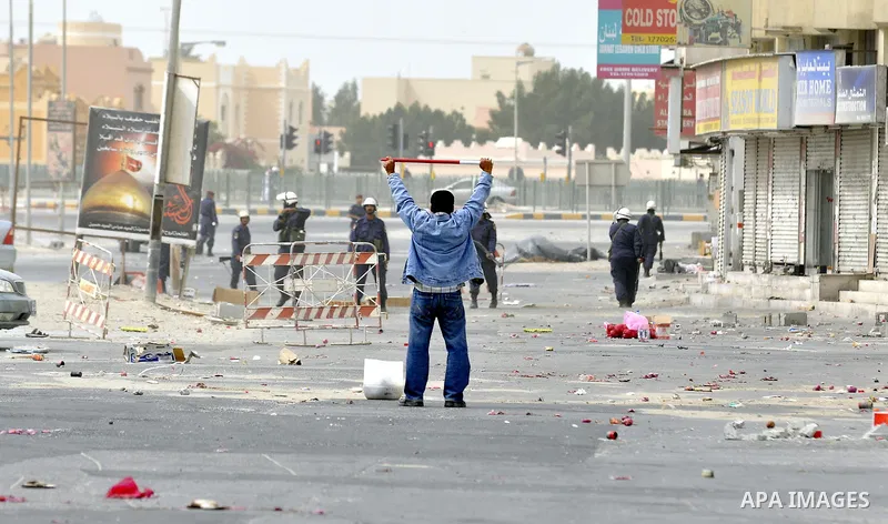 Anti-government protesters run from riot police, Thursday, March 17, 2011, as a tear gas canister explodes nearby in the Shiite Muslim village of Jidhafs, Bahrain, on the outskirts of the capital of Manama. Security forc...