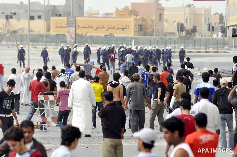 Anti-government protesters run from riot police, Thursday, March 17, 2011, as a tear gas canister explodes nearby in the Shiite Muslim village of Jidhafs, Bahrain, on the outskirts of the capital of Manama. Security forc...