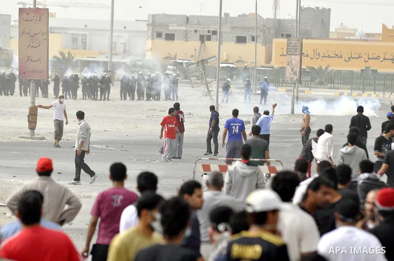 Anti-government protesters run from riot police, Thursday, March 17, 2011, as a tear gas canister explodes nearby in the Shiite Muslim village of Jidhafs, Bahrain, on the outskirts of the capital of Manama. Security forc...
