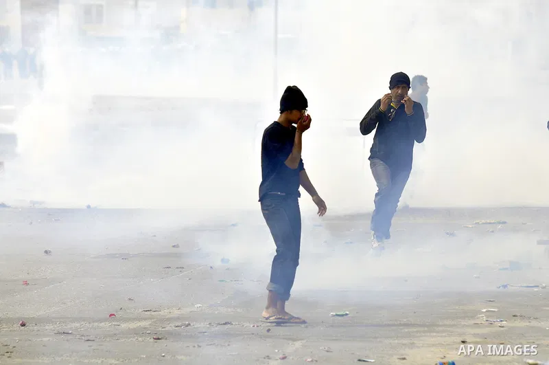 Anti-government protesters run from riot police, Thursday, March 17, 2011, as a tear gas canister explodes nearby in the Shiite Muslim village of Jidhafs, Bahrain, on the outskirts of the capital of Manama. Security forc...