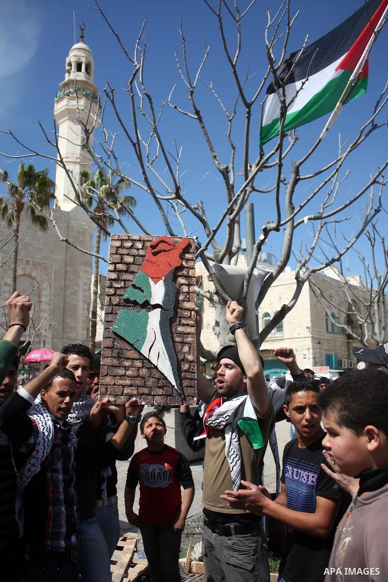 Palestinians chant slogans as they set up a tent in Manager Square in front of the Church of the Nativity in the West Bank city of Bethlehem on March 18, 2011 during a protest calling for Palestinian political unity betw...