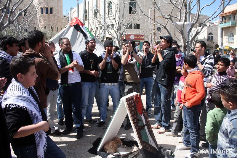 Palestinians chant slogans as they set up a tent in Manager Square in front of the Church of the Nativity in the West Bank city of Bethlehem on March 18, 2011 during a protest calling for Palestinian political unity betw...