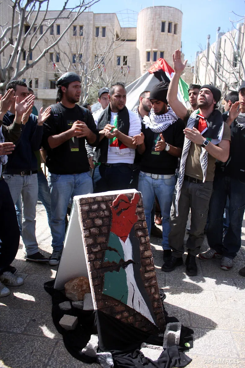 Palestinians chant slogans as they set up a tent in Manager Square in front of the Church of the Nativity in the West Bank city of Bethlehem on March 18, 2011 during a protest calling for Palestinian political unity betw...