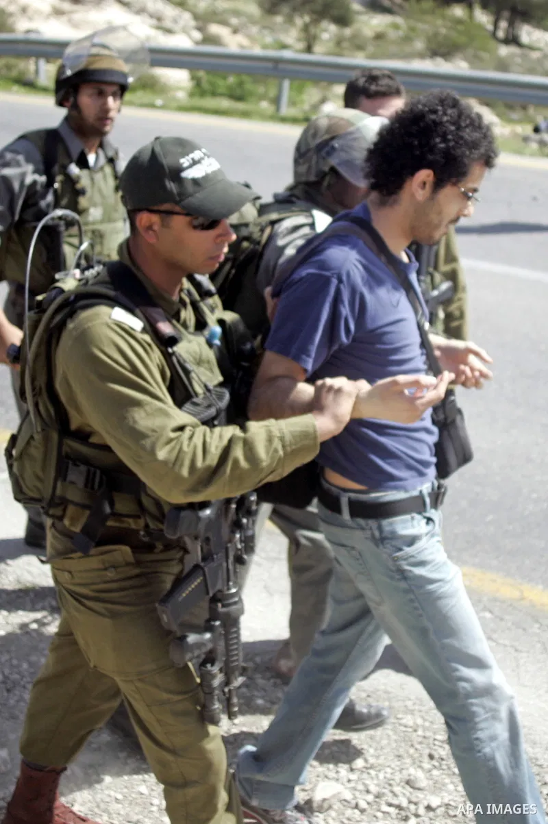 Israeli soldiers arrest a demonstrator during a demonstration against Israel's controversial separation barrier in the West Bank village of Maasarah, near the biblical town of Bethlehem on March 18, 2011.Israel says the...