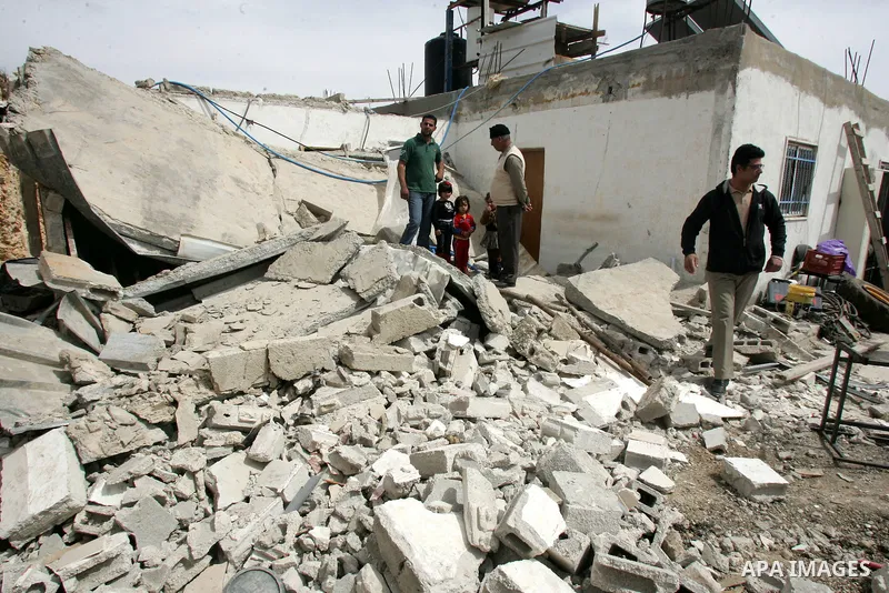 Palestinians stand on the rubble of their house after it was demolished by Israeli army in the Arab Jerusalem neighborhood of Sour Baher on March 19, 2011. Photo by Mahfouz Abu Turk
