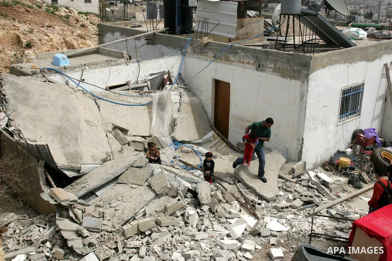 Palestinians stand on the rubble of their house after it was demolished by Israeli army in the Arab Jerusalem neighborhood of Sour Baher on March 19, 2011. Photo by Mahfouz Abu Turk