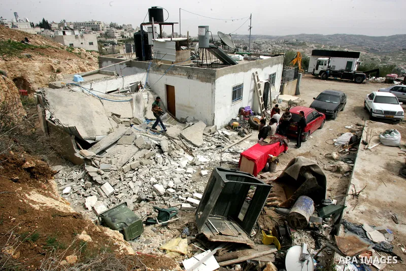 Palestinians stand on the rubble of their house after it was demolished by Israeli army in the Arab Jerusalem neighborhood of Sour Baher on March 19, 2011. Photo by Mahfouz Abu Turk
