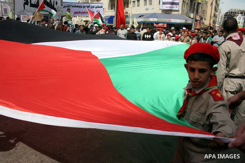 Palestinian scouts carry the national flag as they parade in Manara Square in down town Ramallah on March 19, 2011, calling for unity amongst the Palestinian people. Photo by Issam Rimawi