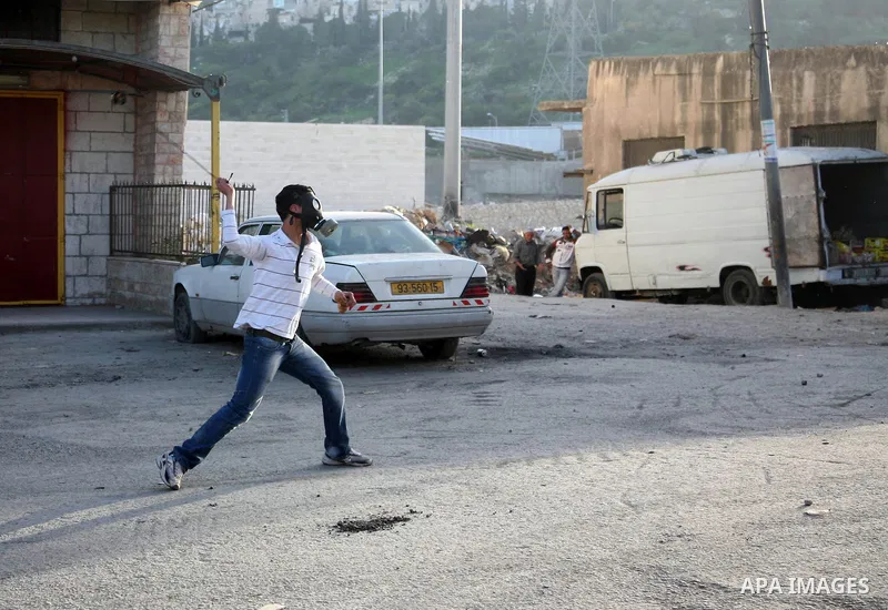 A Palestinian demonstrator throws stones at Israeli soldiers during clashes in the Shufat refugee camp in Jerusalem on March 19, 2011. Hundreds of Palestinians clashed with security forces in east Jerusalem on as tension...