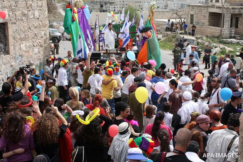 Israelis parade during their celebration of the Jewish holiday of Purim in the divided West Bank city of Hebron, on 20 March 2011. The joyful Jewish holiday of Purim celebrates the Jews' salvation from genocide in ancien...