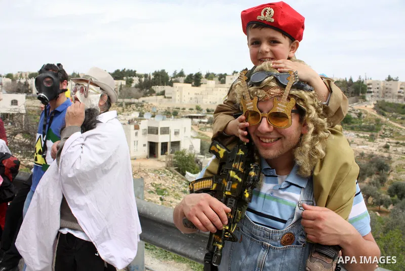Israelis parade during their celebration of the Jewish holiday of Purim in the divided West Bank city of Hebron, on 20 March 2011. The joyful Jewish holiday of Purim celebrates the Jews' salvation from genocide in ancien...