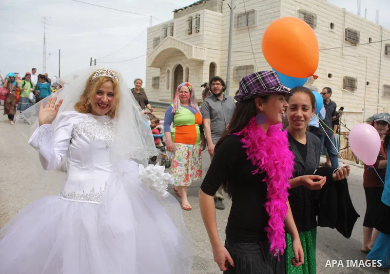 Israelis parade during their celebration of the Jewish holiday of Purim in the divided West Bank city of Hebron, on 20 March 2011. The joyful Jewish holiday of Purim celebrates the Jews' salvation from genocide in ancien...