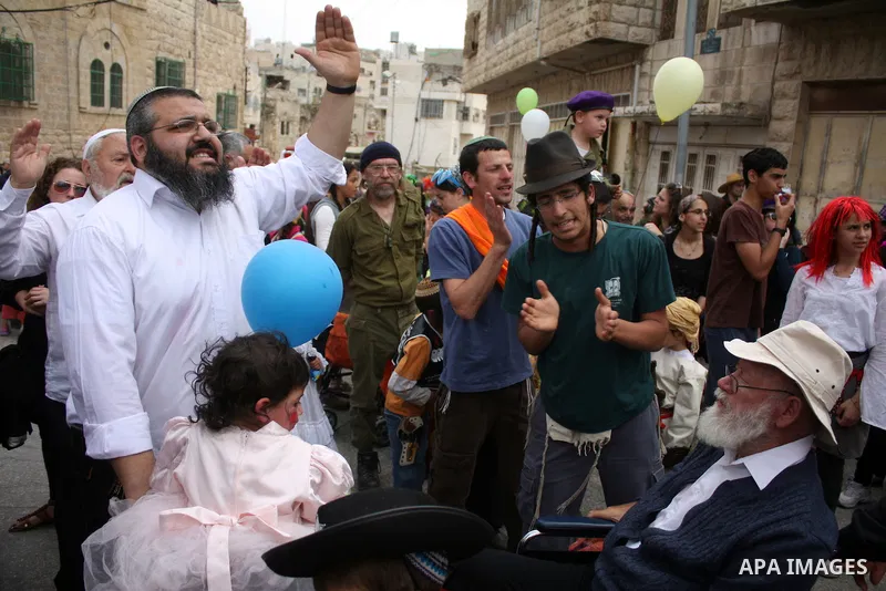 Israelis parade during their celebration of the Jewish holiday of Purim in the divided West Bank city of Hebron, on 20 March 2011. The joyful Jewish holiday of Purim celebrates the Jews' salvation from genocide in ancien...