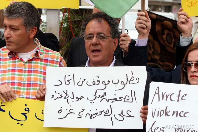 Journalists and photographers hold banners during a protest in the West Bank city of Ramallah, 20 March 2011 following the raid on Reuters office by security forces in Gaza city on 19 March. Photo by Issam Rimawi