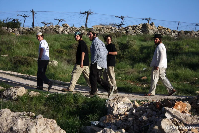 Israeli settlers from the Kharsina settlement throw stones at Palestinian cars on March 21,2011 near Hebron in the Israeli-occupied West Bank, as three Palestinians were wounded by Israeli settlers near the West Bank tow...